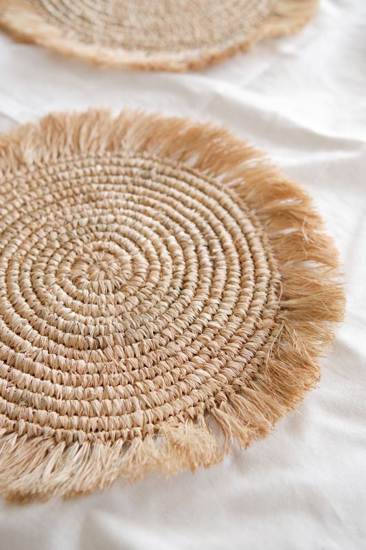 Natural raffia placemat with fringe, suited for boho weddings, rustic events, and stylish cafe or restaurant decor