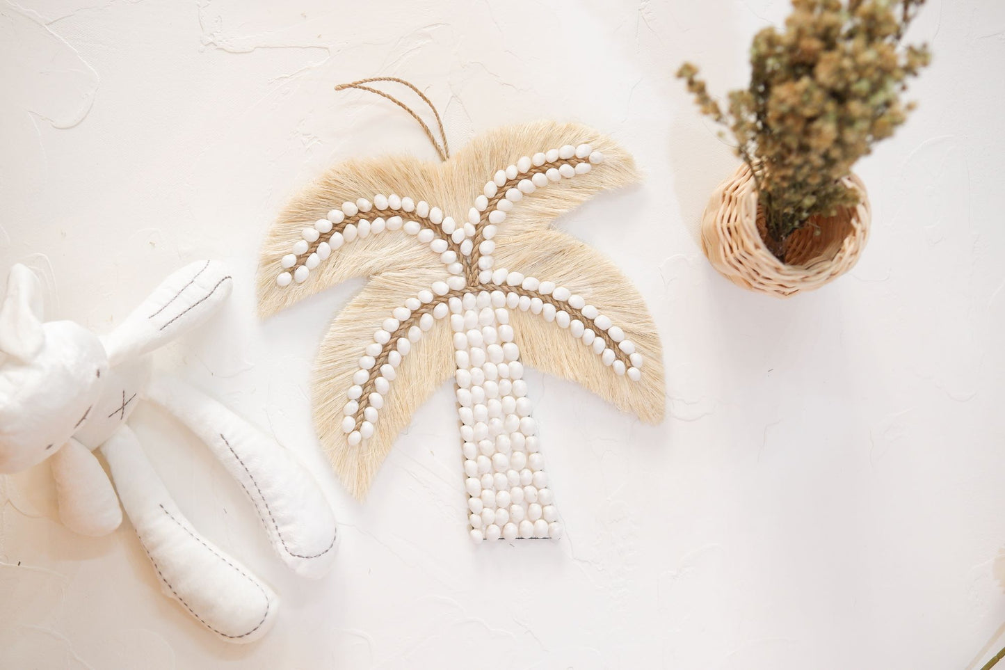 Palm tree sea shell wall decor featuring a decorative doll and daisy flower, perfect for adding a touch of coastal and coquette charm to any room