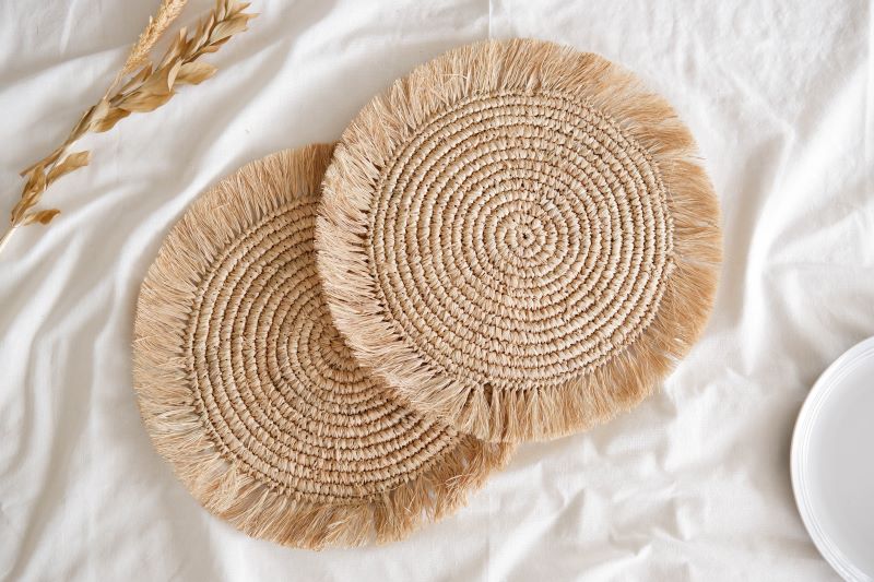 Natural raffia placemat with fringe, suited for boho weddings, rustic events, and stylish cafe or restaurant decor