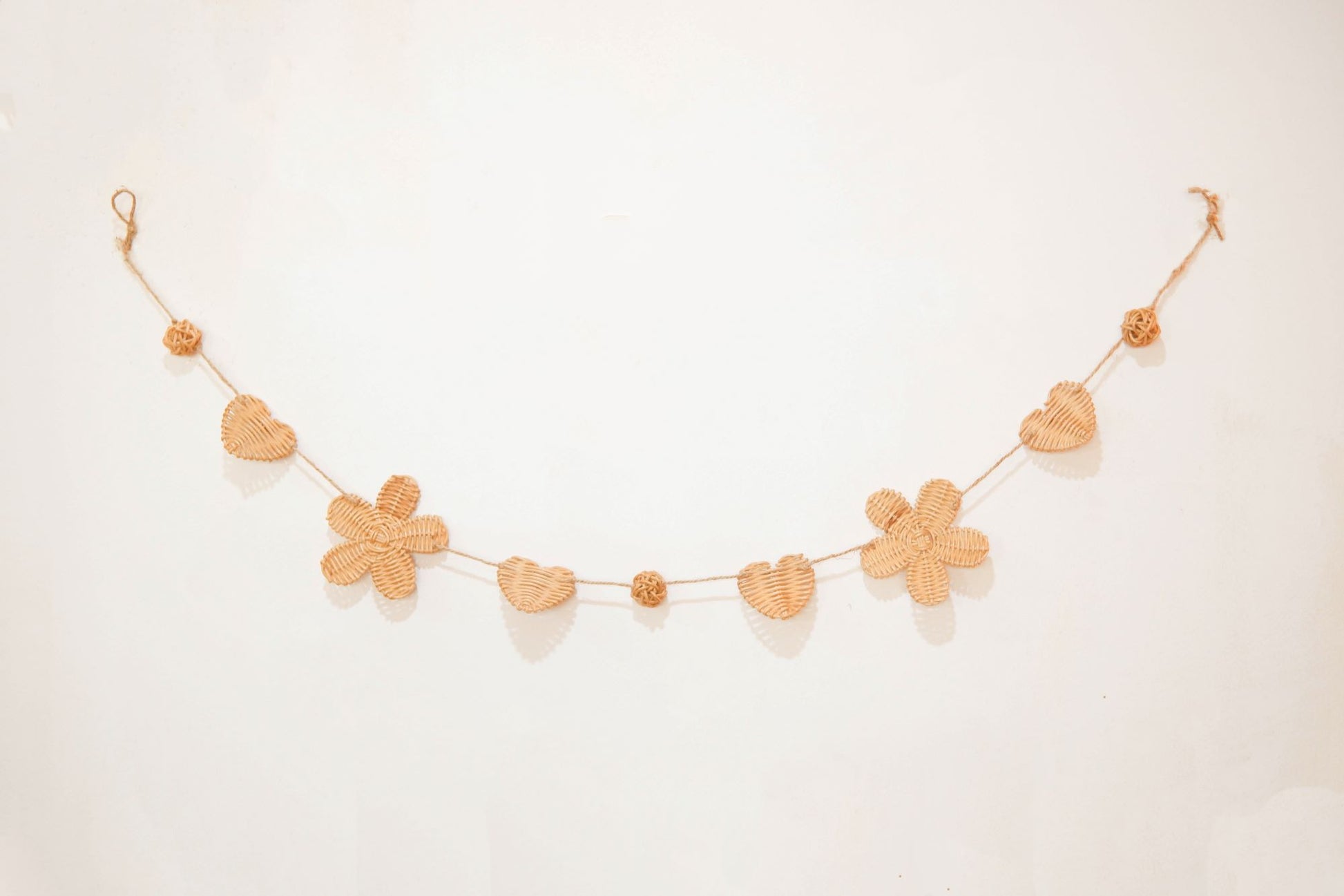 Rattan and felt daisy garland for kids' room decor and baby party, perfect for adding a boho theme.