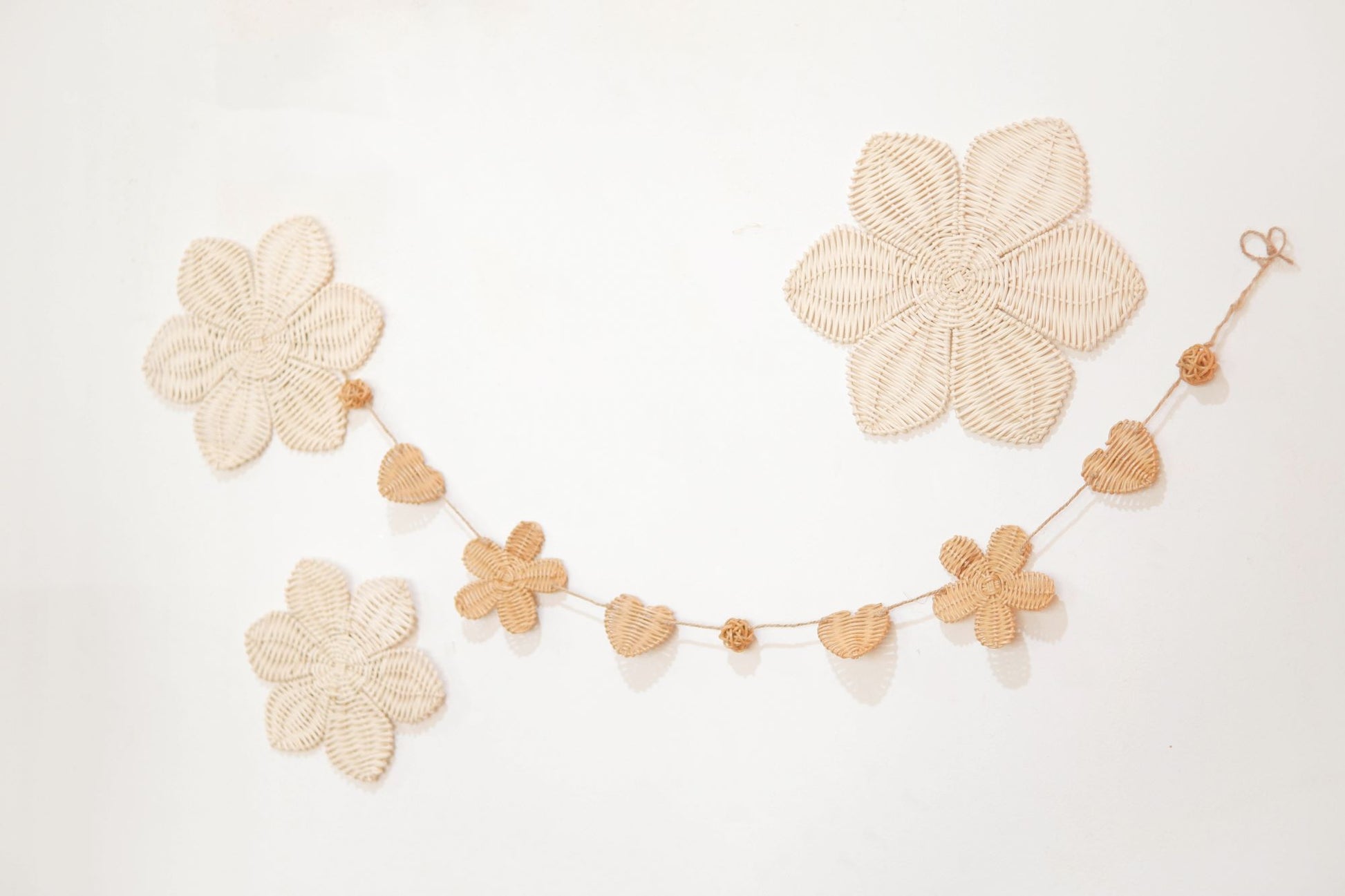 Rattan and felt daisy garland for kids' room decor and baby party, perfect for adding a boho theme.