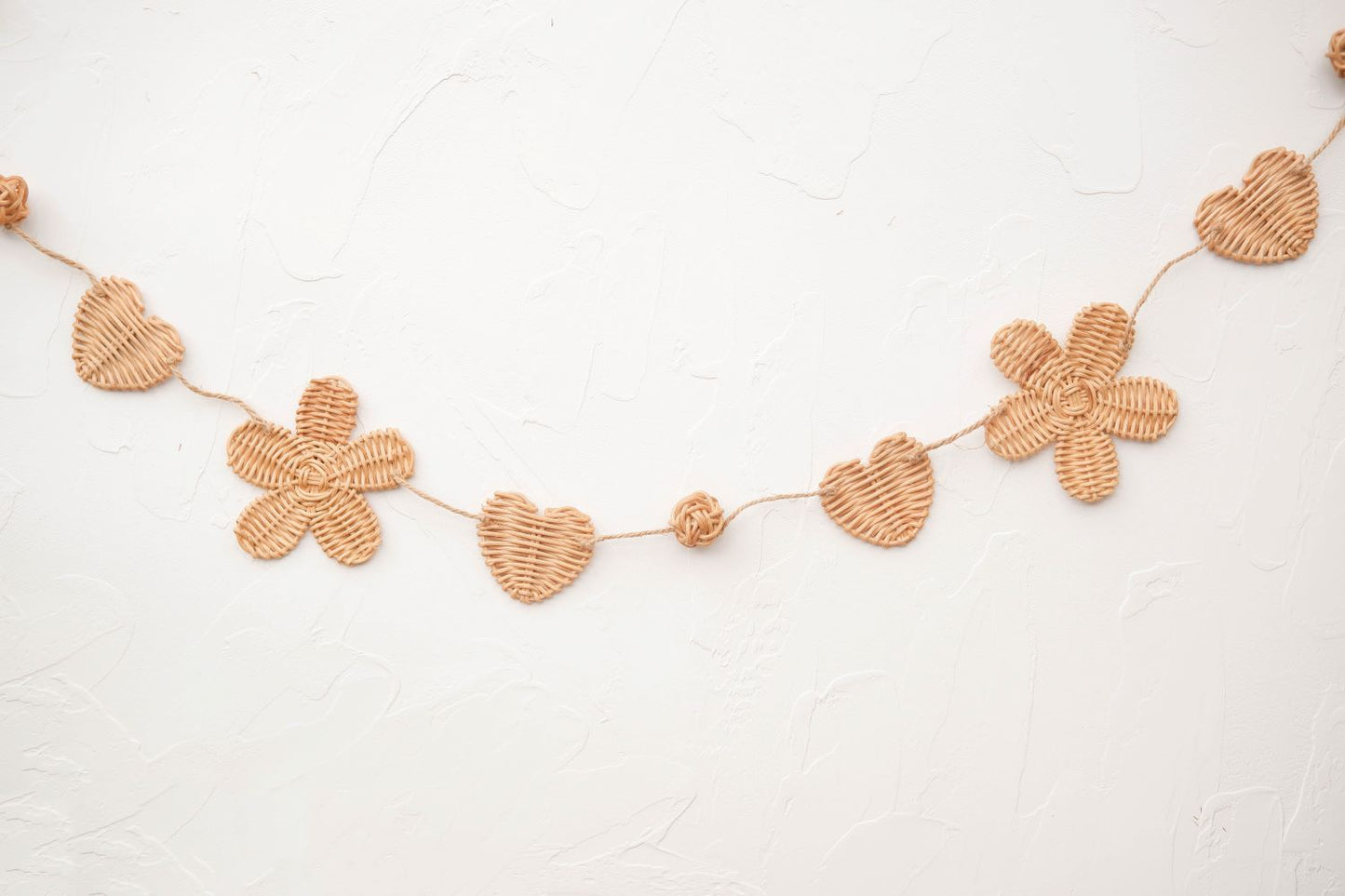 Rattan and felt daisy garland for kids' room decor and baby party, perfect for adding a boho theme.