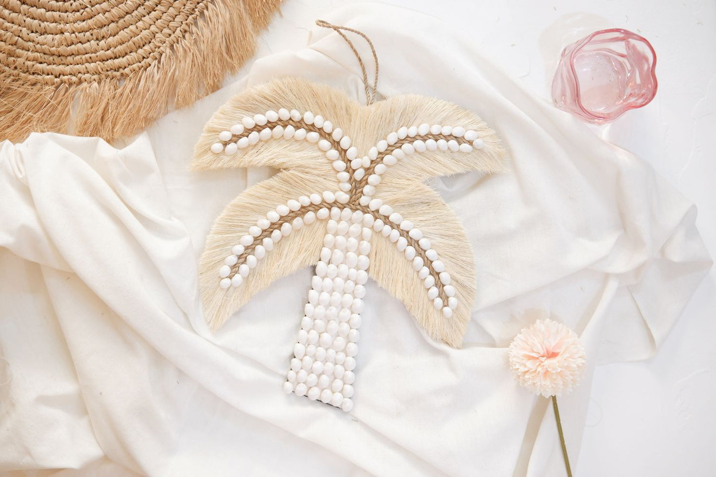 Palm tree sea shell wall decor featuring a pink glass and a flower, perfect for adding a touch of coastal and coquette charm to girls room, nursery room, and boho home decor