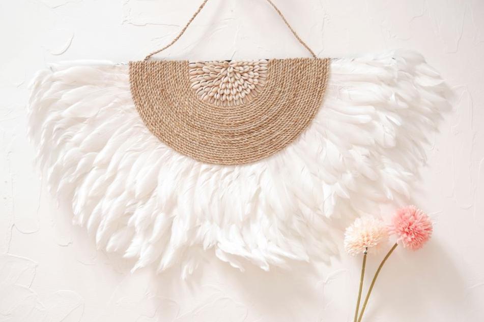 White Juju Hat Wall Decor featuring soft feathers and sea shell accents, perfect for boho beach bedroom, living room decor. Adds a natural, coastal vibe to any space with its textured, handcrafted design.