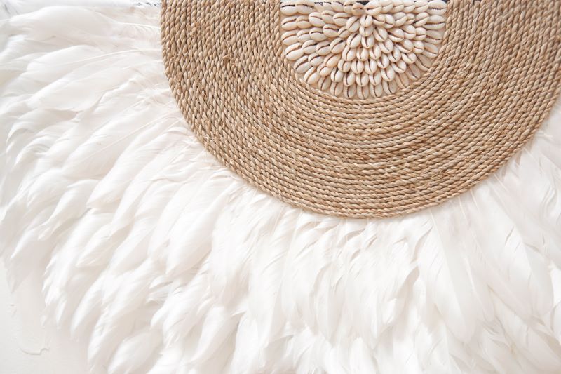 White Juju Hat Wall Decor featuring soft feathers and sea shell accents, perfect for boho beach bedroom, living room decor. Adds a natural, coastal vibe to any space with its textured, handcrafted design.