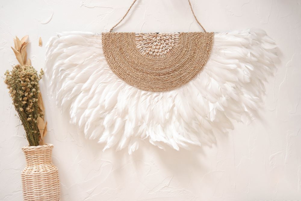 White Juju Hat Wall Decor featuring soft feathers and sea shell accents, perfect for boho beach bedroom, living room decor. Adds a natural, coastal vibe to any space with its textured, handcrafted design.